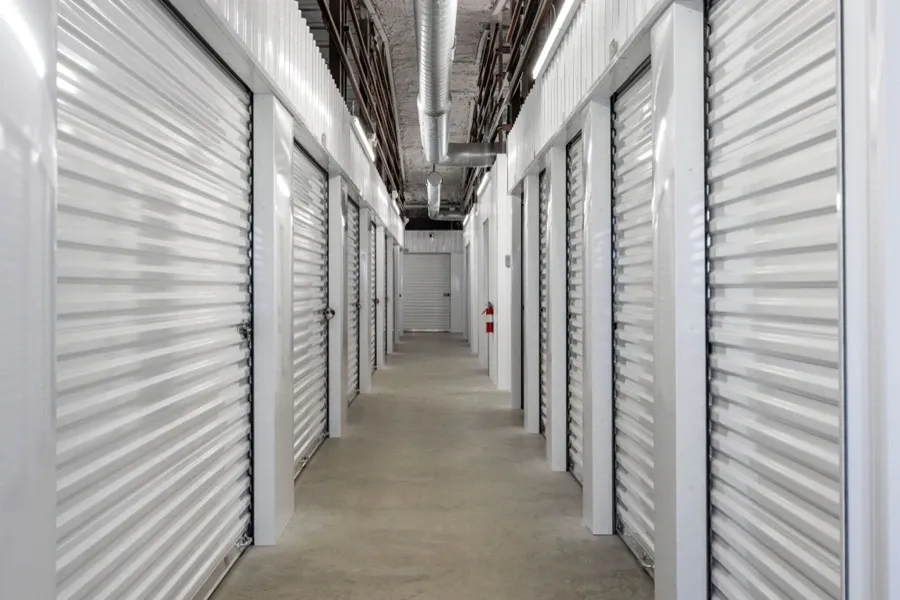 Interior hallway of a self storage facility with white doors.