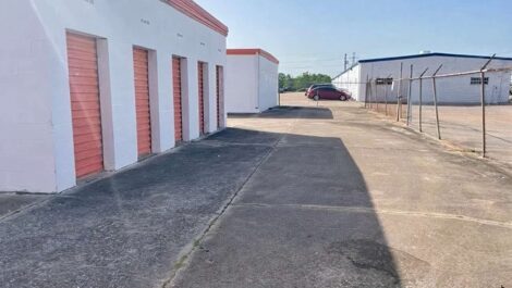 row of self storage units with drive up fenced around